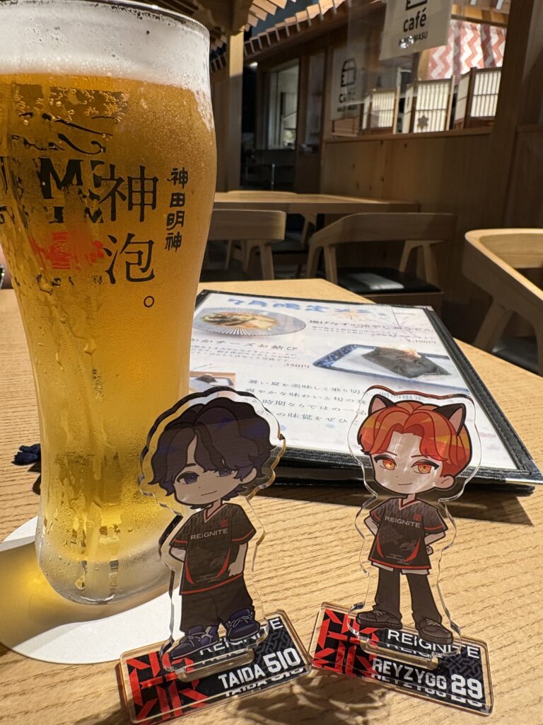 生ビールのグラスの手前に並べたREIGNITEメンバーのアクリルスタンド