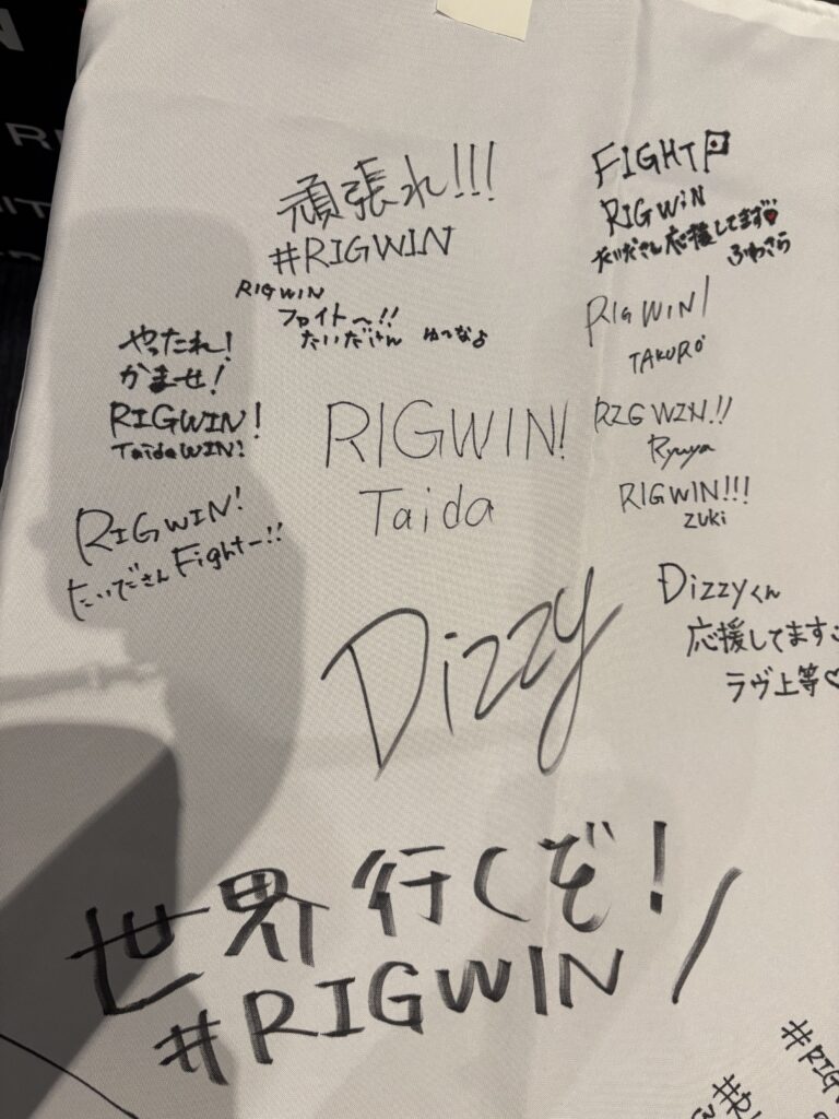 「世界行くぞ！#RIGWIN」と書かれた出演者の寄せ書き